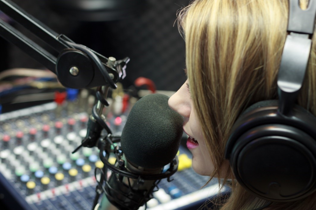 Young Girl Presenting in Radio Station Spreading News of Charity Work in Business