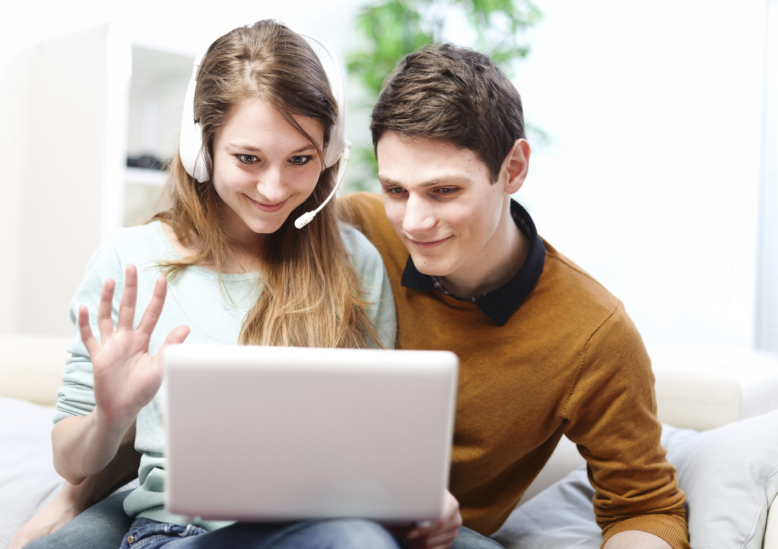 Happy young couple talking through the computer with video chat