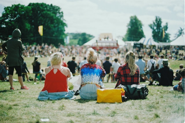 Three girls at a festival wearing silicone wristbands